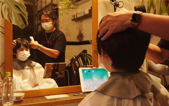 どんな髪型にするか美容師と相談する河辺さん